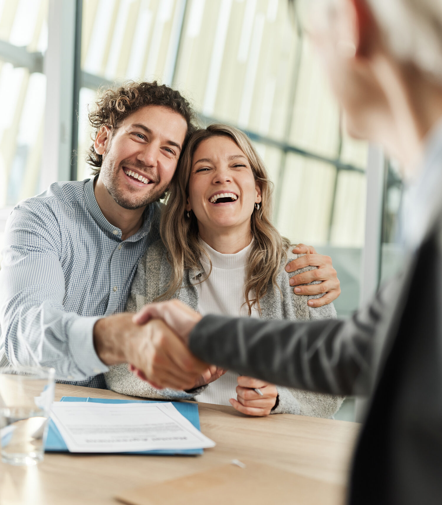 Happy couple came to an agreement with their agent in the office.